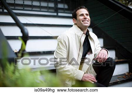 Stock Image - Man sitting on front steps. Fotosearch