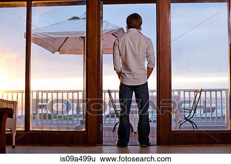 Man standing in doorway of patio View Large Photo Image Stock Photograph - Man standing in doorway of patio. Fotosearch