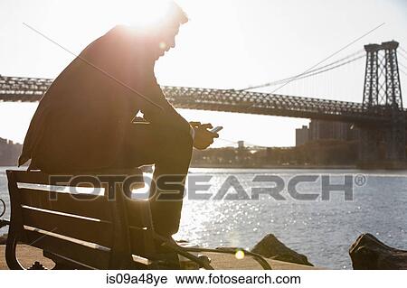 Man using cell phone by urban bridge View Large Photo Image Stock Image - Man using cell phone by urban bridge. Fotosearch