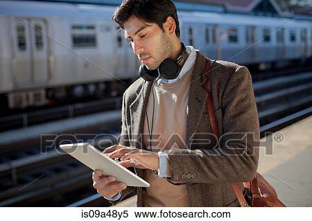 Man using tablet computer at station View Large Photo Image Stock Photography - Man using tablet computer at station. Fotosearch