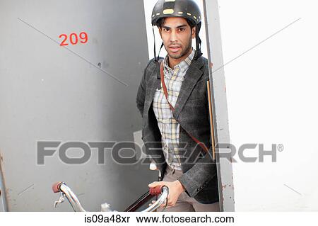 Stock Photography - Man wheeling bicycle out apartment door. Fotosearch