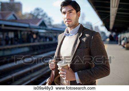Man with cup of coffee at train station View Large Photo Image Stock Image - Man with cup of coffee at train station. Fotosearch