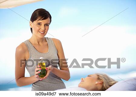 Masseuse holding bottle of oil outdoors View Large Photo Image Stock Photo - Masseuse holding bottle of oil outdoors. Fotosearch