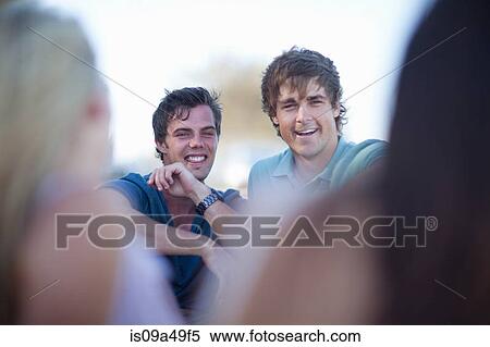 Stock Photography - Men laughing together outdoors. Fotosearch