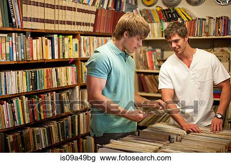 Men shopping together in thrift store View Large Photo Image Stock Image - Men shopping together in thrift store. Fotosearch