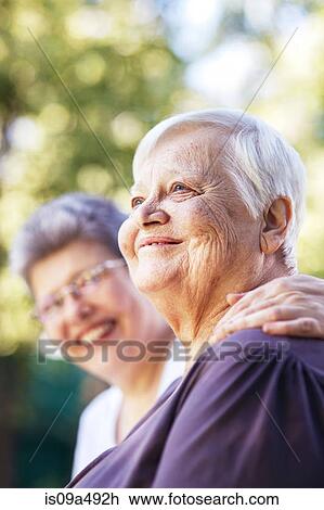 Older women smiling together outdoors View Large Photo Image Stock Image - Older women smiling together outdoors. Fotosearch
