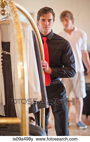 Porter pushing luggage cart in hotel View Large Photo Image Stock Photo - Porter pushing luggage cart in hotel. Fotosearch
