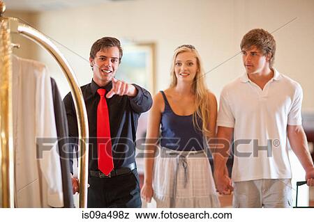 Porter talking to couple in hotel lobby View Large Photo Image Stock Photo - Porter talking to couple in hotel lobby. Fotosearch