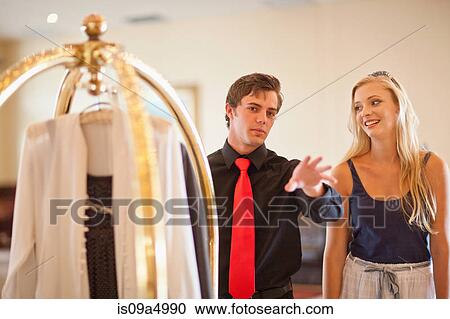 Stock Image - Porter talking to woman in hotel lobby. Fotosearch
