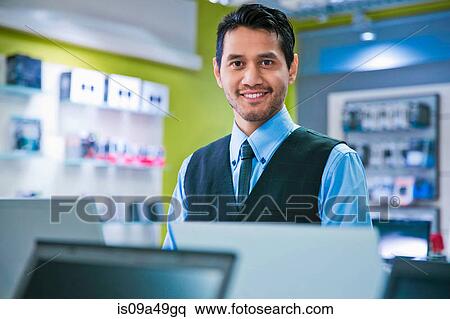 Stock Photography - Salesman smiling in store. Fotosearch