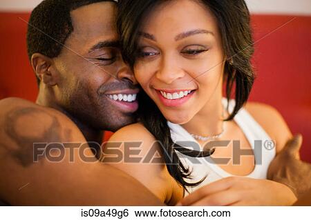 Smiling couple hugging in bed View Large Photo Image Stock Photograph - Smiling couple hugging in bed. Fotosearch