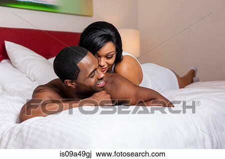 Smiling couple laying on bed View Large Photo Image Stock Image - Smiling couple laying on bed. Fotosearch