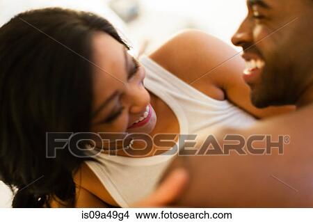 Picture - Smiling couple playing in bed. Fotosearch