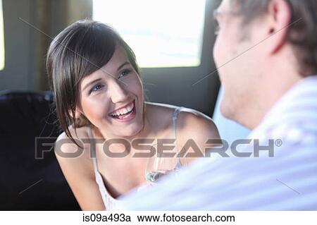 Stock Image - Smiling couple talking indoors. Fotosearch