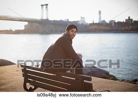 Smiling man sitting on park bench View Large Photo Image Stock Image - Smiling man sitting on park bench. Fotosearch