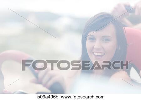 Stock Image - Smiling woman driving jeep. Fotosearch
