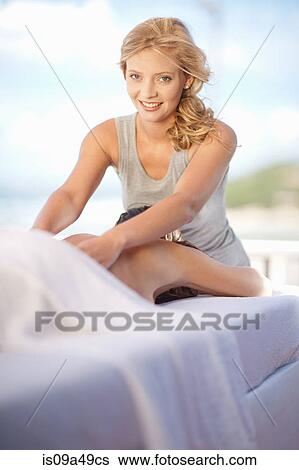 Stock Photograph - Smiling woman giving massage outdoors. Fotosearch