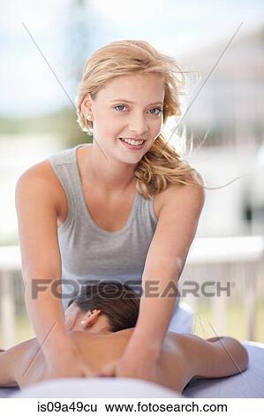 Smiling woman giving massage outdoors View Large Photo Image Stock Photograph - Smiling woman giving massage outdoors. Fotosearch