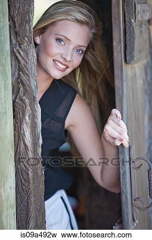 Smiling woman opening door View Large Photo Image Stock Photo - Smiling woman opening door. Fotosearch