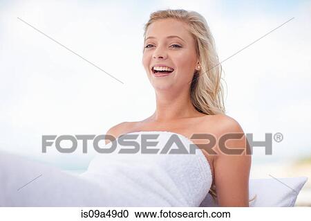 Stock Image - Smiling woman relaxing outdoors. Fotosearch