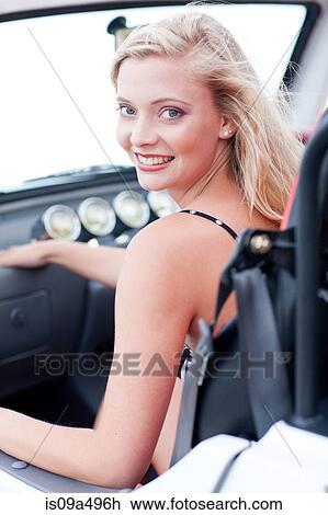 Stock Image - Smiling woman riding in jeep. Fotosearch