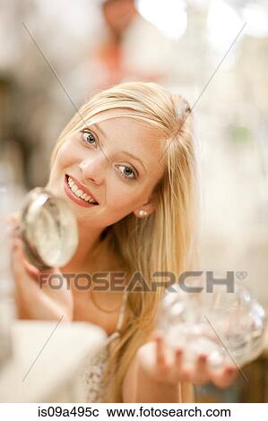 Stock Image - Smiling woman shopping in store. Fotosearch