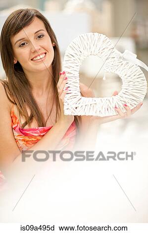 Stock Image - Smiling woman shopping in store. Fotosearch