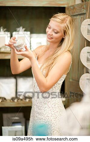 Stock Image - Smiling woman shopping in store. Fotosearch