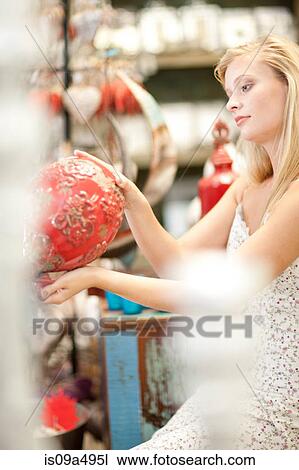 Stock Image - Smiling woman shopping in store. Fotosearch
