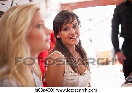 Stock Image - Smiling woman sitting in cafe. Fotosearch