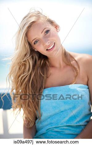 Stock Image - Smiling woman sitting outdoors. Fotosearch