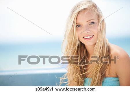 Stock Image - Smiling woman sitting outdoors. Fotosearch