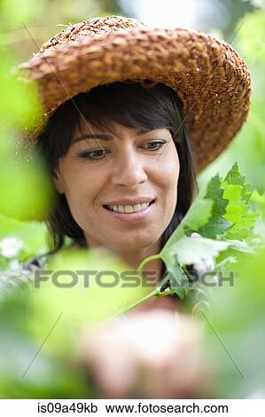 Smiling woman standing in tall plants View Large Photo Image Stock Image - Smiling woman standing in tall plants. Fotosearch