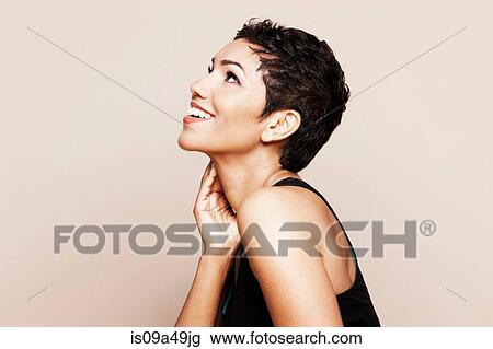 Stock Image - Smiling woman standing indoors. Fotosearch