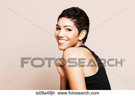 Stock Image - Smiling woman standing indoors. Fotosearch
