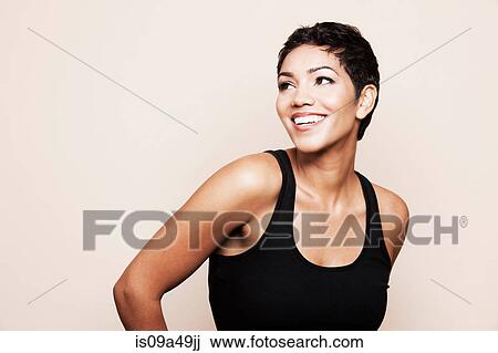Stock Image - Smiling woman standing indoors. Fotosearch