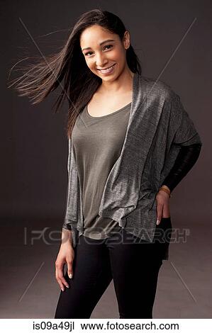 Stock Image - Smiling woman standing indoors. Fotosearch