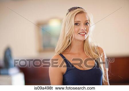 Stock Photograph - Smiling woman standing indoors. Fotosearch