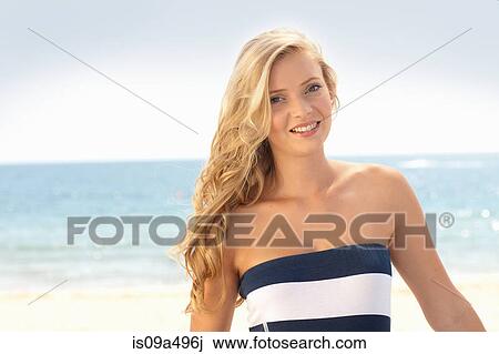 Smiling woman standing on beach View Large Photo Image Stock Image - Smiling woman standing on beach. Fotosearch