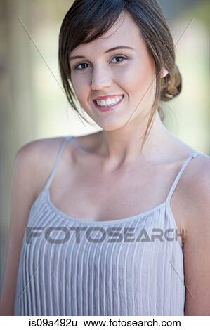 Smiling woman standing outdoors View Large Photo Image Stock Photograph - Smiling woman standing outdoors. Fotosearch
