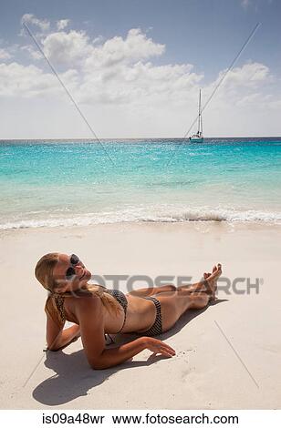 Smiling woman sunbathing on beach View Large Photo Image Stock Photography - Smiling woman sunbathing on beach. Fotosearch