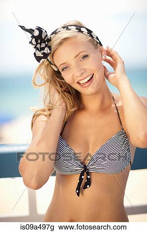 Smiling woman tying scarf in hair View Large Photo Image Stock Image - Smiling woman tying scarf in hair. Fotosearch