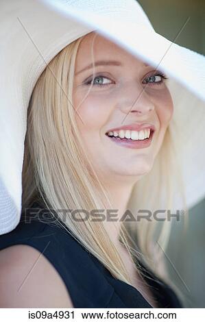 Stock Image - Smiling woman wearing hat. Fotosearch