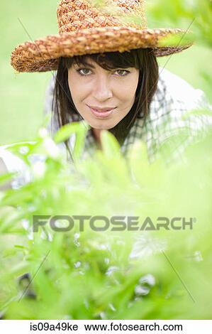 Smiling woman working in garden View Large Photo Image Stock Image - Smiling woman working in garden. Fotosearch