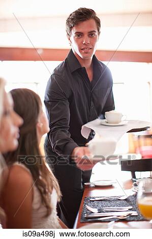 Waiter serving women in cafe View Large Photo Image Stock Image - Waiter serving women in cafe. Fotosearch