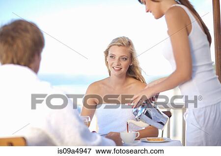 Waitress serving woman coffee at table View Large Photo Image Stock Photo - Waitress serving woman coffee at table. Fotosearch
