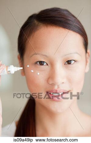 Woman applying moisturizer in bathroom View Large Photo Image Stock Photography - Woman applying moisturizer in bathroom. Fotosearch