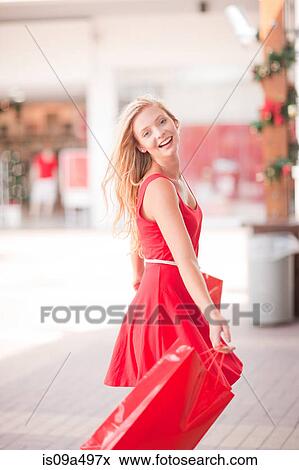 Stock Photo - Woman carrying shopping bags in mall. Fotosearch