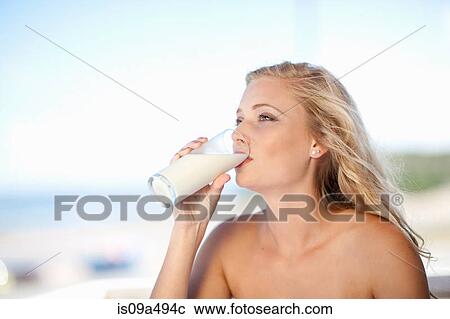 Stock Image - Woman drinking glass of milk outdoors. Fotosearch