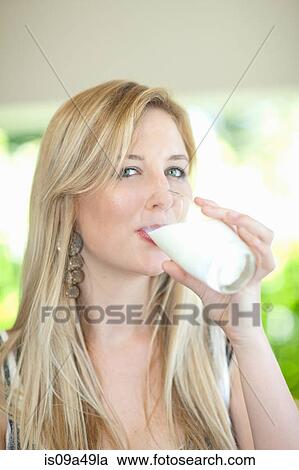 Stock Image - Woman drinking glass of milk outdoors. Fotosearch